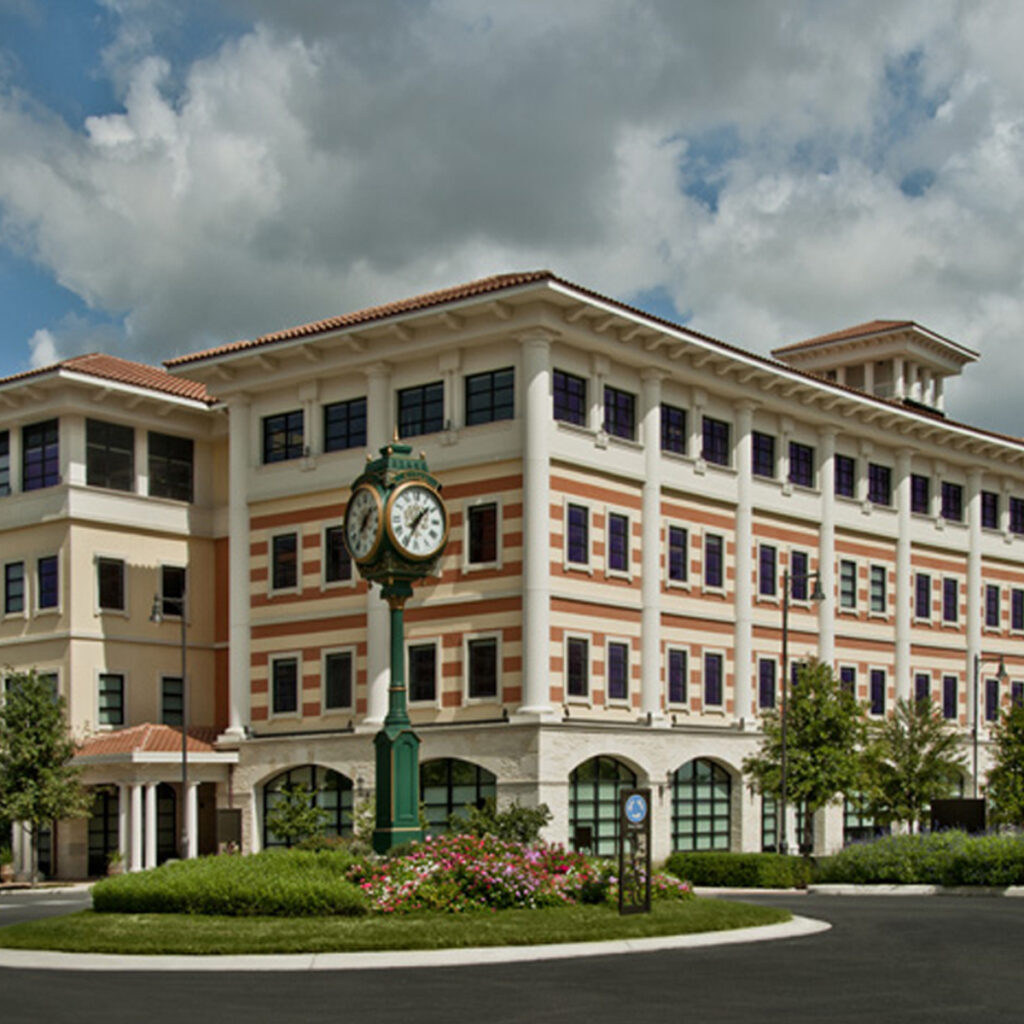 Exterior of Eilan Offices with green clock outside within the landscaping.