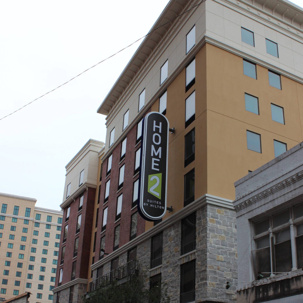 Exterior of Hampton Inn and Home 2 Suites shown at an angle from a distance.