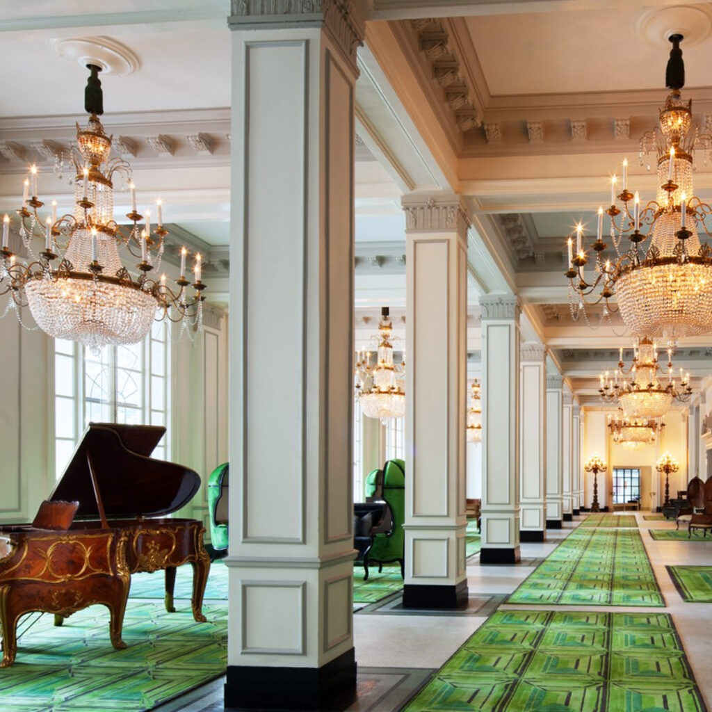 Interior lobby of the hotel with green carpet and crystal chandelier.